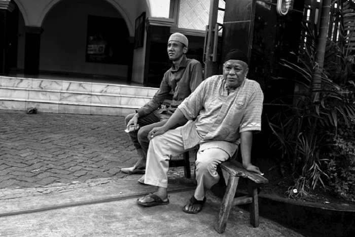 Two men sit outside a mosque in Kemang Timur, Jakarta © Arnaldo Pellini