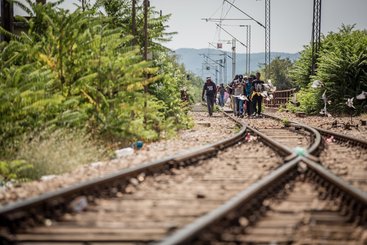 A group of migrants walk on the last leg of their crossing from Greece to FYR of Macedonia