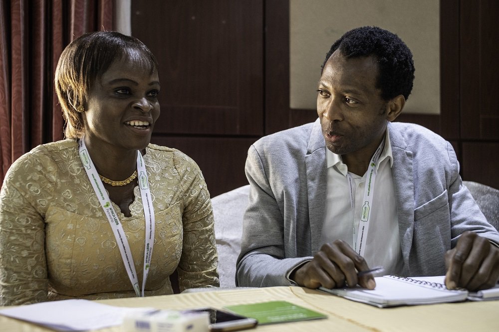 Africa Mini-Grids Community of Practice members Rhoda Mando and Abbas AbdulRafiu compare notes at the 2018 workshop in Abuja, Nigeria. Photo: Geraint Hill, 2018