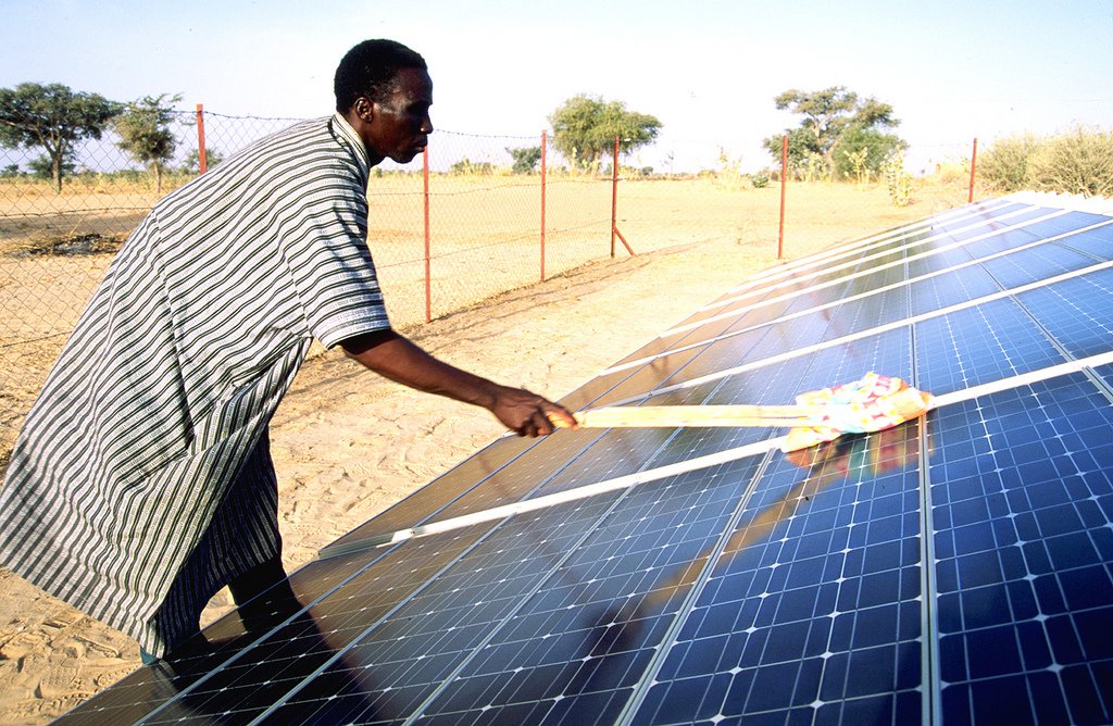 A man cleans a solar panel in Niger. Photo: Adam Rogers/United Nations Capital Development Fund, 2002 (CC BY-NC-ND 2.0)