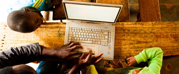 African kids and teacher using laptop