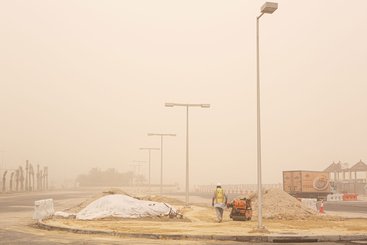 Migrant workers in Kuwait keep on toiling during a sandstorm