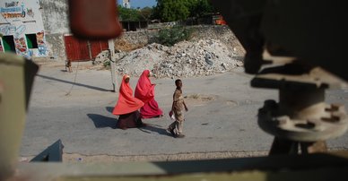 Women in bright headscarves walk along Mogadishu street, Somalia. AMISOM.