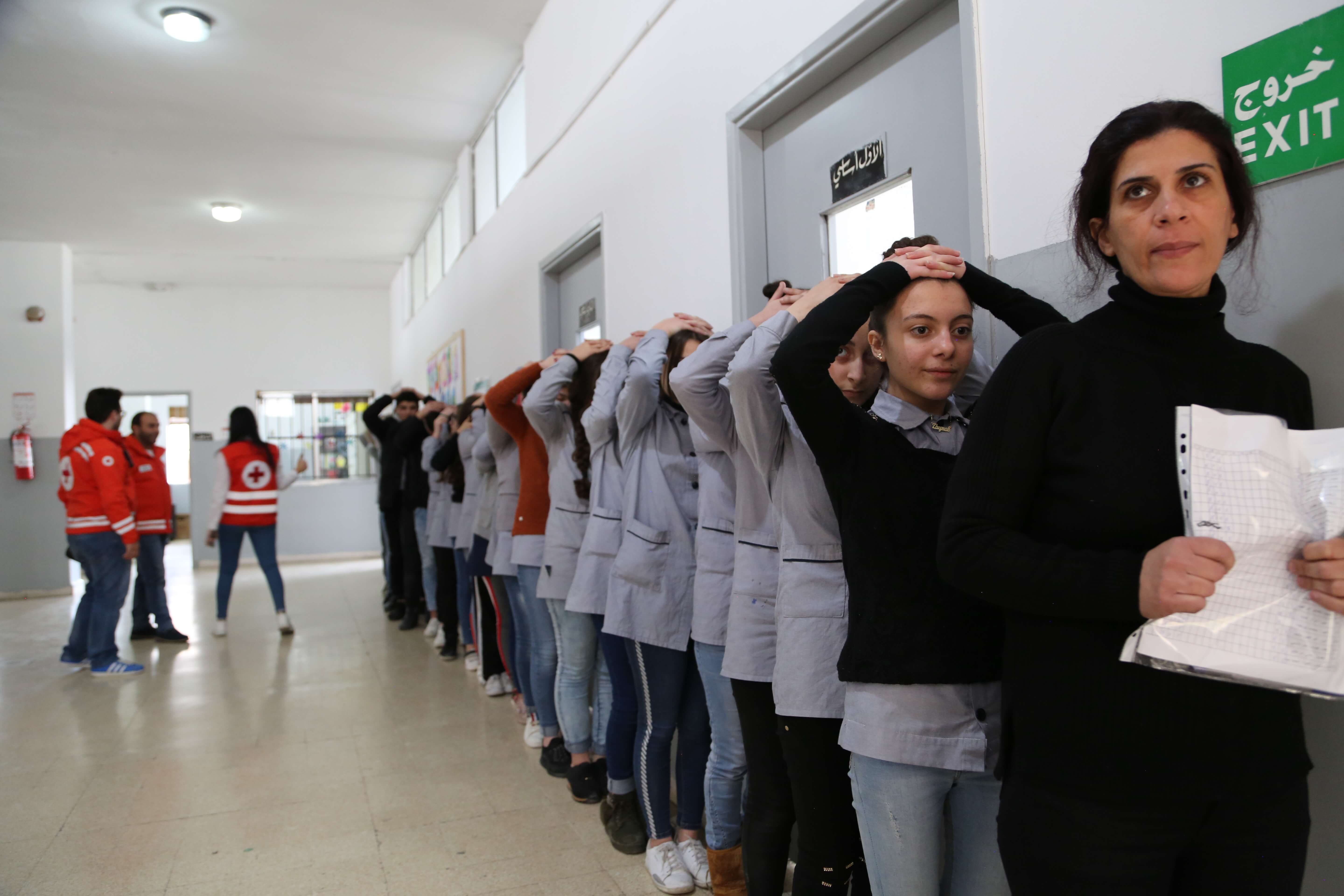 A teacher and students conduct a safety drill, coordinated by the volunteers from the Lebanese Red Cross, at Al-Quba School in Tripoli, Lebanon, March 27, 2019.