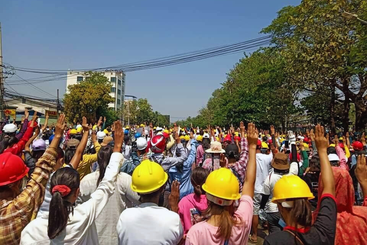 Protesters in Myanmar holding up a 3 finger salute