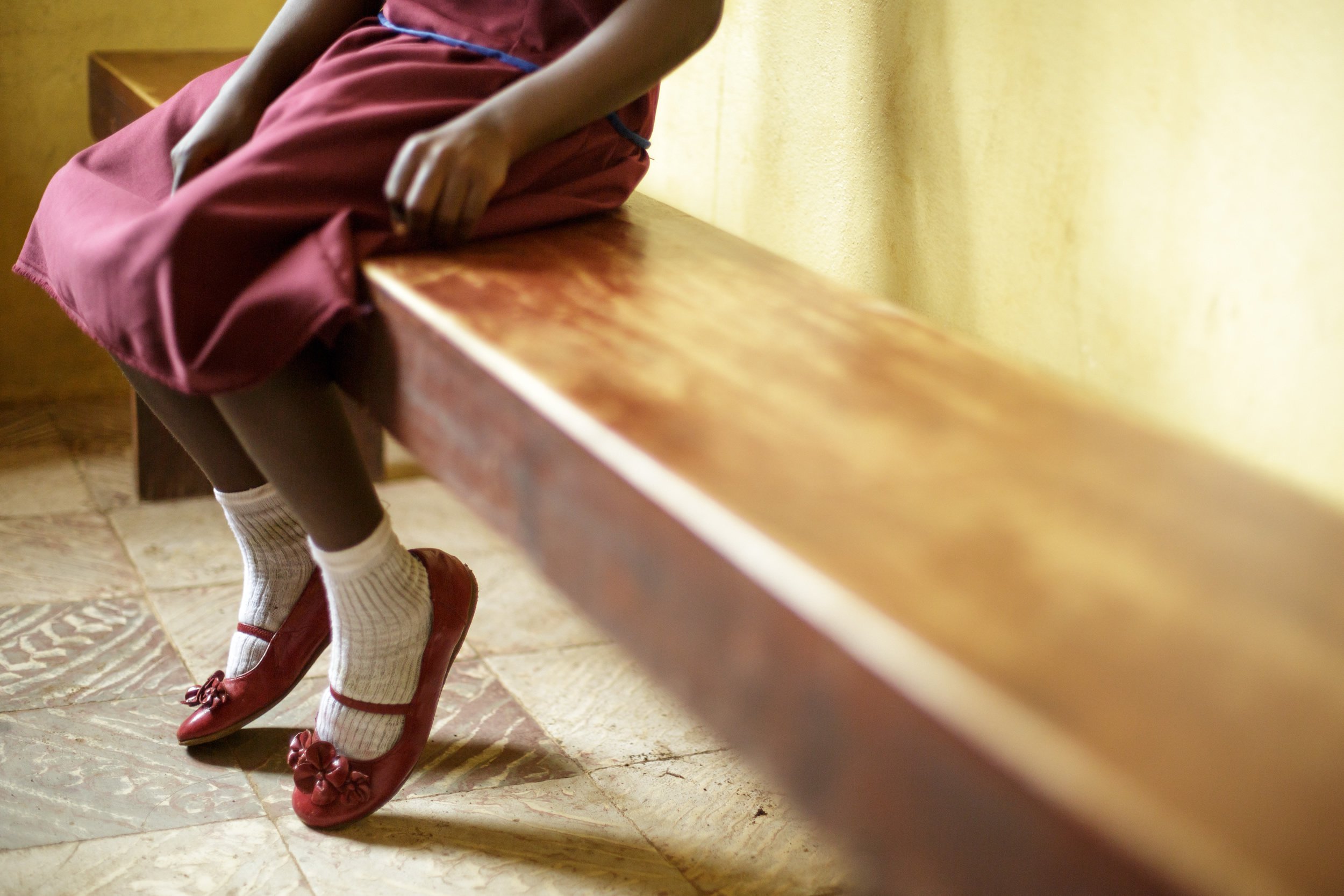 A young girl sits on a bench. Photo UNICEF/Olivier Asselin CC BY-SA 2.0
