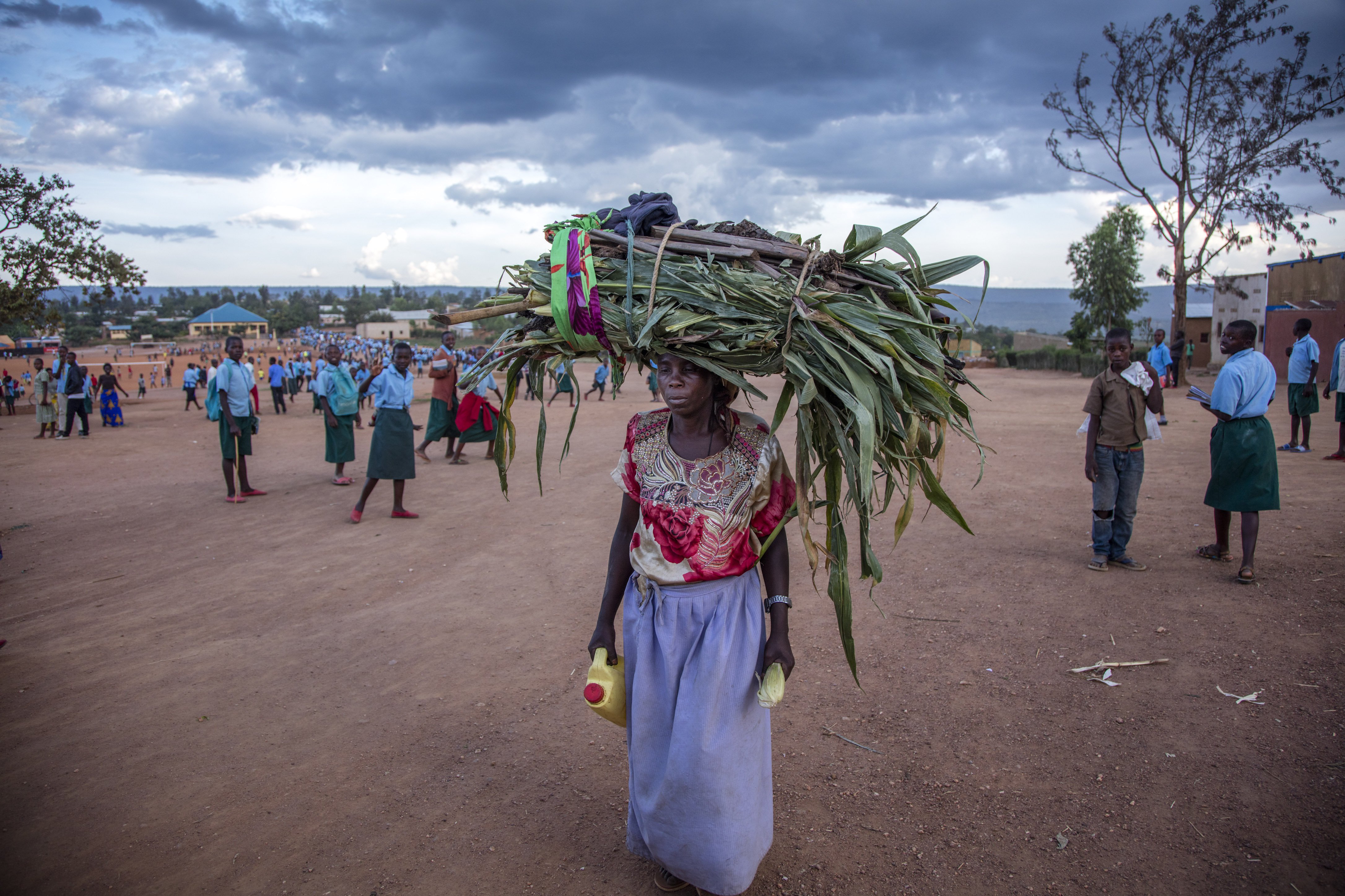 A woman carries grass for her cows through Mahama refugee camp in Kirehe, eastern Rwanda