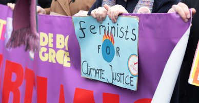 Woman marching and holding a sign saying Feminists for climate justice ©ElenaBaryshnikova | Shutterstock ID:1667268439